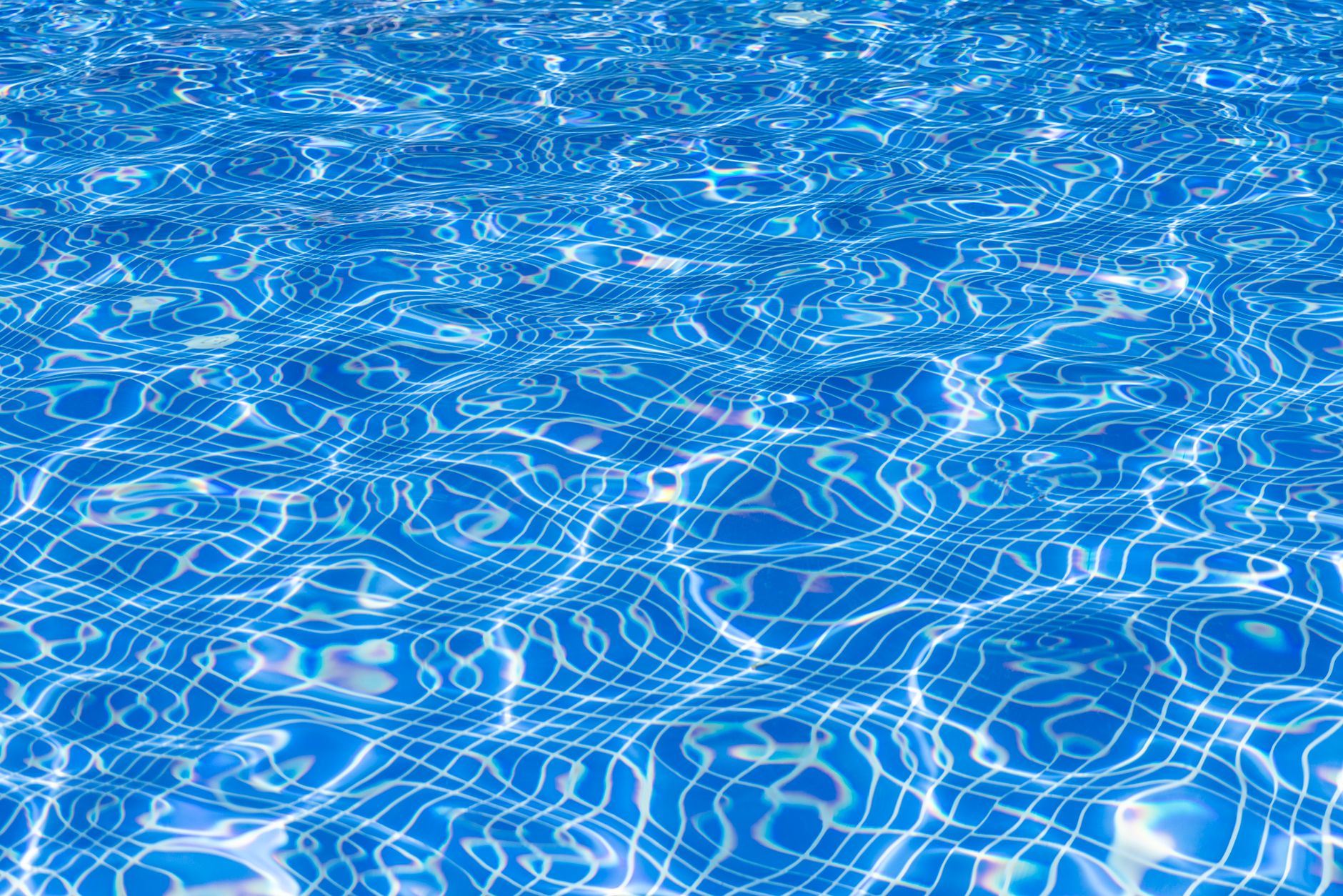 Crystal-clear blue backyard pool under afternoon sun after algae prevention in Yuma, Arizona