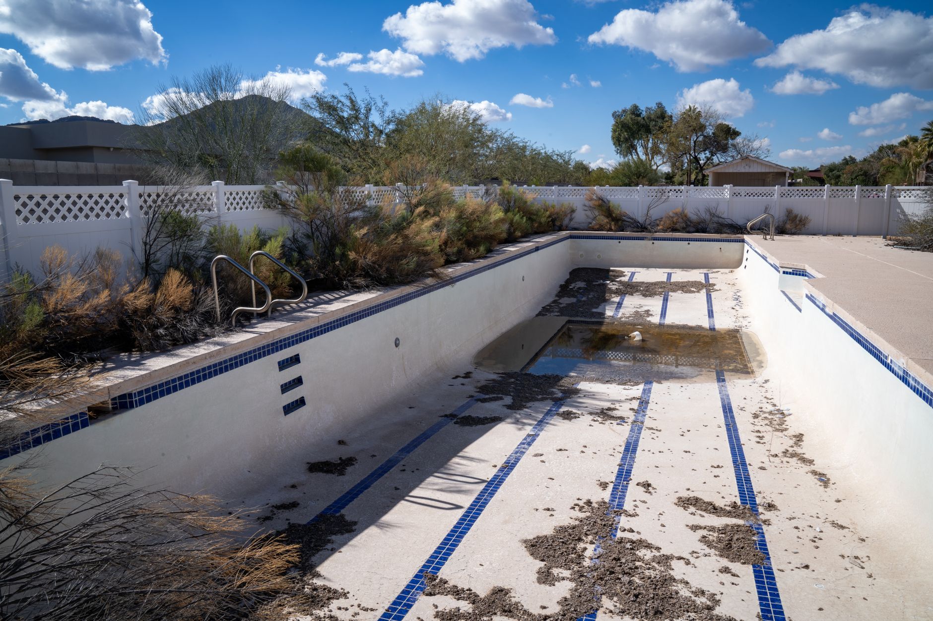 A pool technician measuring waterline loss to detect a leak in Yuma Arizona