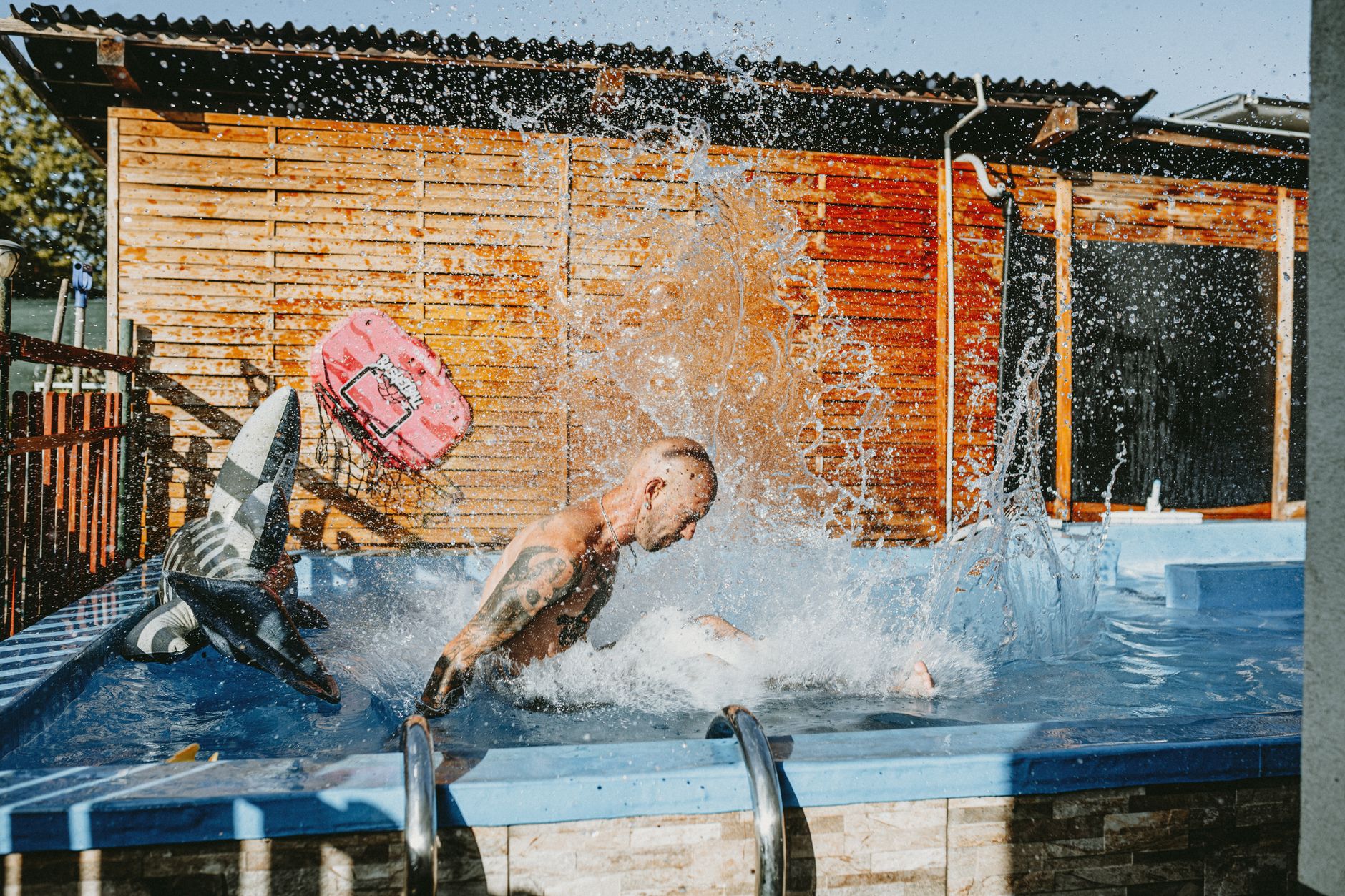 A pool technician skimming a clear backyard pool on one of our weekly pool service plans in Yuma