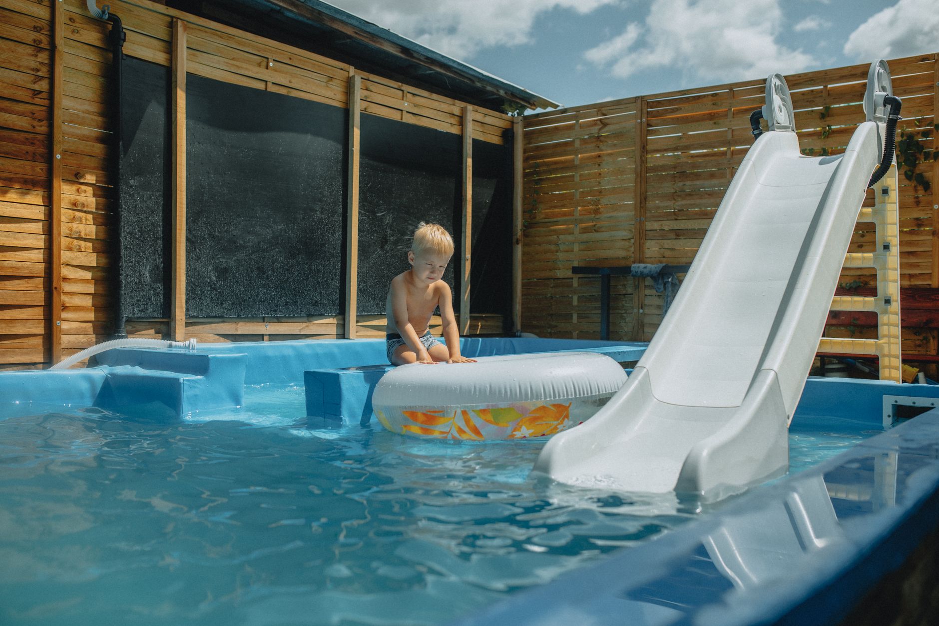 A technician inspecting post-winter pool equipment, including the pump and filter, at a Yuma backyard pool
